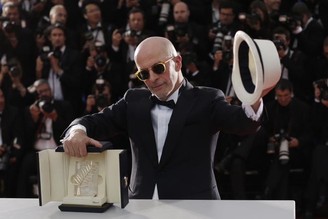 Director Jacques Audiard holds the Palme d'Or award for the film Dheepan as he poses for photographers during a photo call following the awards ceremony at the 68th international film festival, Cannes, southern France, Sunday, May 24, 2015. (AP Photo/Thibault Camus)