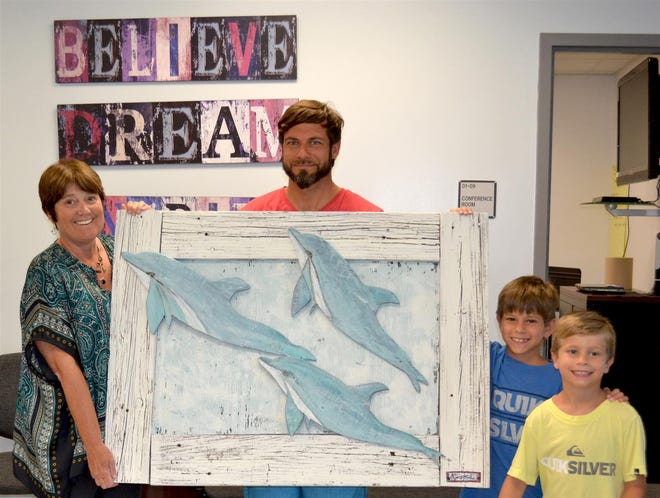 Local artist, Andy Saczynski presented this piece of artwork to DES Principal Janet Stein last week. Pictured with him are his sons, Noah (second grade) and Jonah (kindergarten).