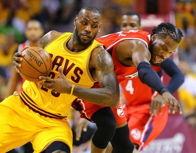 Cleveland Cavaliers LeBron James, left, and Hawks DeMarre Carroll battle for a loose ball during game four of the Eastern Conference Finals on Tuesday, May 26, 2015, in Cleveland.   (Curtis Compton/Atlanta Journal-Constitution via AP) MARIETTA DAILY OUT; GWINNETT DAILY POST OUT; LOCAL TELEVISION OUT; WXIA-TV OUT; WGCL-TV OUT
