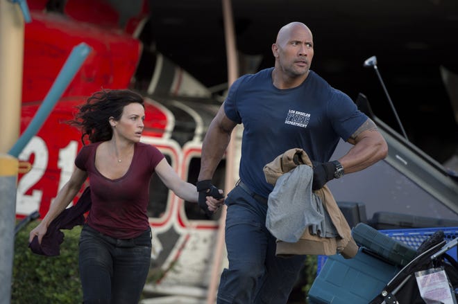 Carla Gugino, left, as Emma, and Dwayne Johnson as Ray race from danger in the action thriller, "San Andreas." Jasin Boland/Warner Bros. Pictures