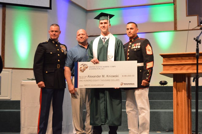 Alex Kniowski, 17, of Holland, poses for a photo with the $180,000 NROTC scholarship at the Calvary Schools of Holland graduation ceremony Thursday, May 28, at Calvary Baptist Church. Erin Dietzer/Sentinel Staff