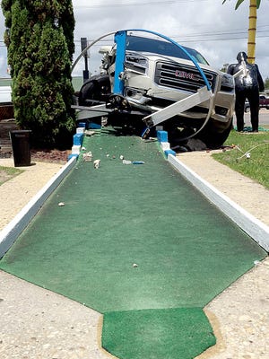 An SUV rests atop the windmill at Goofy Golf on Saturday after a crash on Eglin Parkway. No injuries were reported.