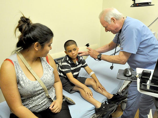 Dr. Stephen Knight examines Ryan Real, as his mother Pricilla looks on, in an examination room at Florida Hospital-DeLand, in DeLand on Thursday.