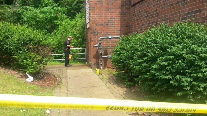 An Aliquippa police officer notes different pieces of evidence outside the doorway of the Valley Terrace Apartments E Building Saturday afternoon where a shooting occurred just before 2 p.m. As a result one person was taken to an area hospital.