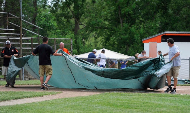 The tarp is placed on home plate on Hudson High School’s baseball field Saturday. The district final was postponed until Monday.
