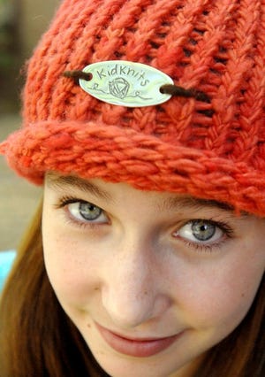 Ellie Zika models a KidKnits hat. Yarn hand spun in Chile and Rwanda is used in all KidKnit kits.