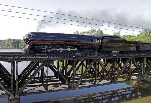 The Norfolk & Western Class J No. 611 steam locomotive crosses a bridge over the Yadkin River after leaving the North Carolina Transportation Museum in Spencer on Saturday. The train, which has undergone a yearlong restoration, is returning to the Virginia Museum of Transportation in Roanoke.