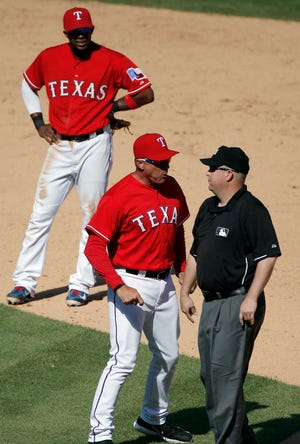 Texas shortstop Elvis Andrus, left, looks on as second base umpire Todd Tichenor ejects manager Jeff Banister during the ninth inning of a game against the Boston Red Sox on Sunday in Arlington. Banister was arguing that Boston runner Rusney Castillo came off of the base on a steal, but was ruled safe. Texas won, 4-3.