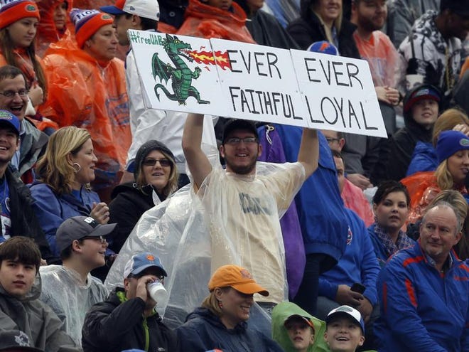 In this Saturday, Jan. 3, 2015, file photo, an UAB fan declares his loyalty for the terminated football program at the Birmingham Bowl NCAA college football game between Florida and East Carolina, in Birmingham, Ala. UAB president Ray Watts is bringing the football program back. He told The Associated Press that he decided on Monday, June 1, 2015 to reverse the earlier decision after meetings with UAB supporters continued through the weekend. He says donors have pledged to make up the estimated $17.2 million deficit over the next five years if football is restored.