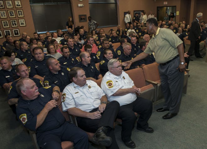 Fayetteville Councilman Chalmers McDougald shakes hands with Fayetteville firefighters at City Hall on Monday, June 1, 2015.