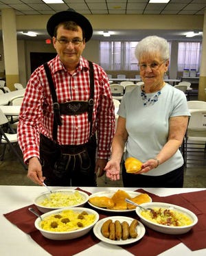 The Rev. Tim Haberkorn and Maureen Steinbock show off some of the dishes that will be available at Sacred Heart-St. Joseph Parish's annual Germanfest. The festival will be from 5 to 11 p.m. Saturday and 10 a.m. to 5 p.m. Sunday.