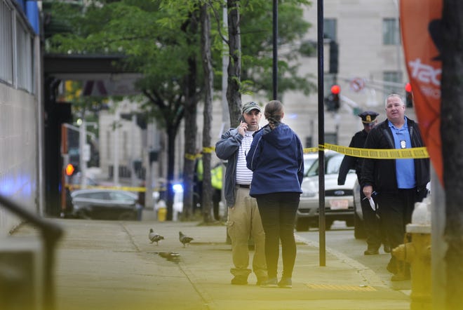 Worcester police investigators work inside a cordoned off area of Main Street on Tuesday after a stabbing was reported. The crime scene was the entire length of the sidewalk from Compare Foods to just past the Aurora Hotel. A blood trail about 120 feet long was visible. T&G Staff/Christine Peterson