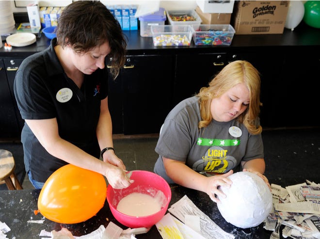 Heather Maise, left and Katie Lipscomb make paper mache dinosaur eggs at the Hardin Center in Gadsden, Ala. on Thursday May 28, 2015. The eggs will be hidden on a walking trail as part of National Trail Day.
