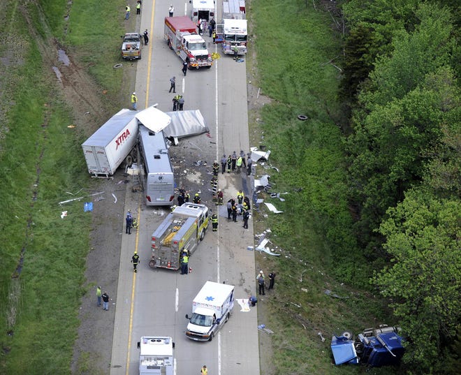 Authorities investigate the scene of a fatal collision between a tractor-trailer and a tour bus on Interstate 380 nearTobyhanna on Wednesday. Three people were killed and more than a dozen were sent to hospitals. (David Kidwell/Associated Press)