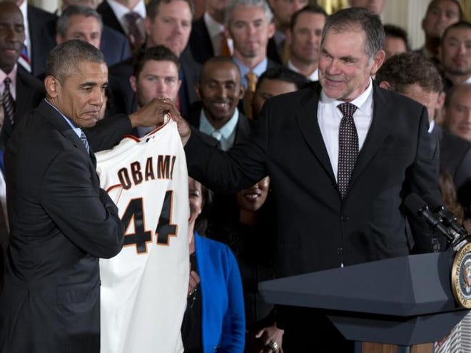 President Barack Obama holds a personalized San Francisco Giants jersey given to him by team manager Bruce Bochy, right, during a ceremony in the East Room of the White House in Washington, Thursday where the president honored the team and their 2014 World Series baseball victory.