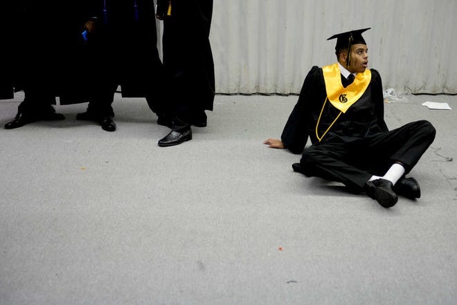 Ian Maule/ Savannah Morning News-Groves High School graduate Michael Winn sits on the ground before the start of his graduation ceremony at the Savannah Civic Center on Wednesday, June 3rd, 2015.