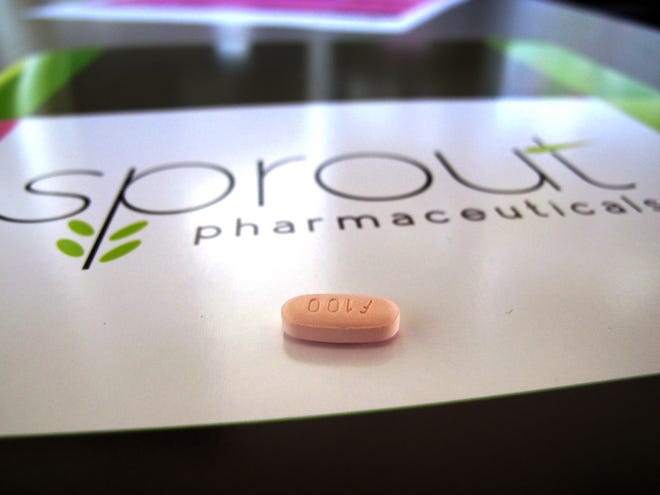 FILE - In this Friday, Sept. 27, 2013, file photo, a tablet of flibanserin sits on a brochure for Sprout Pharmaceuticals in the company's Raleigh, N.C., headquarters.