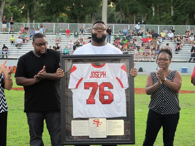 Former Santa Fe Raider Linval Joseph appeared at halftime during the Raiders' spring football game last Friday night to celebrate the retiring of his No. 76 high school jersey. To his right is his brother, Issac Joseph. To his left is his mother, Ernestine Johnson.