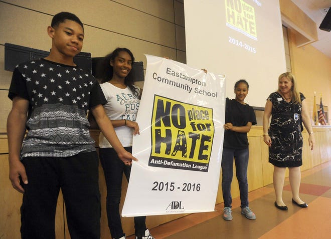 Lisa Friedlander of the Anti-Defamation League presents a banner to the 8th grade class officers, from left Joshua Harmon, Kayla Laurore and Jaiza Lindsey of the Eastampton Community School during an assembly Friday, in which the school was designated "No Place for Hate" by the Anti-Defamation League. Schools must complete several projects, among other requirements, aimed at instilling tolerance and respect to achieve designation as "No Place for Hate."
