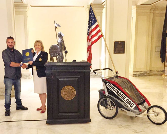 Noah Coughlan, who is running across the country to raise awareness for rare diseases, receives a commendation from Gov. Mary Fallin during his visit to Oklahoma. [Photo provided]