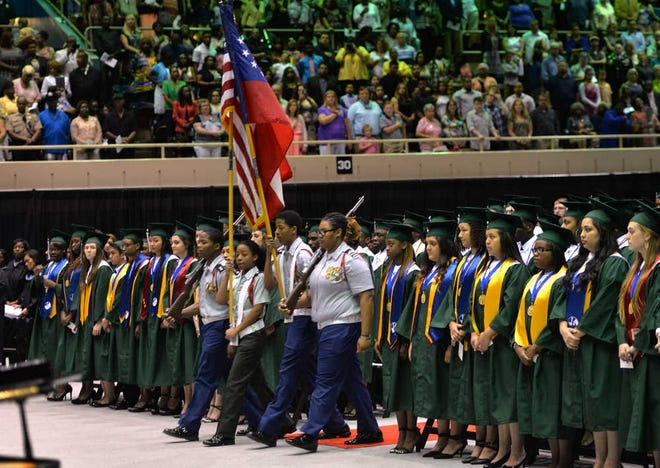 Steve Bisson/Savannah Morning News - The JROTC from Windsor Forest High School bring in the colors at graduation in the Civic Center.