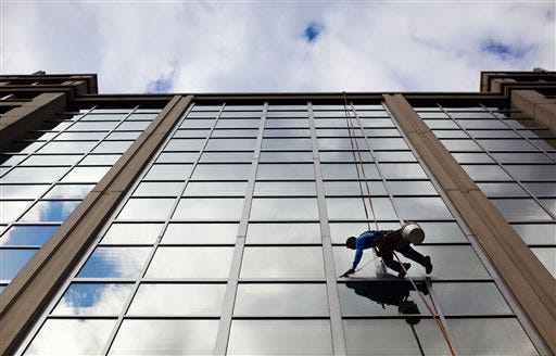 FILE - In this April 23, 2015 file photo, a window washer cleans the windows of an office building in downtown Washington. The U.S. government issues the May jobs report on Friday, June 5, 2015. (AP Photo/Pablo Martinez Monsivais, File)