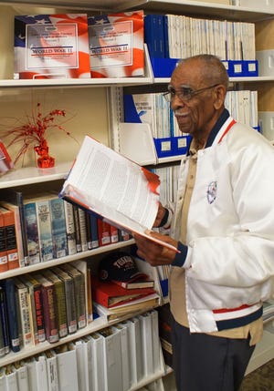 A set of the history books is kept in the special collections room at Cooper Memorial Library in Clermont. Here, Tuskegee Airman Daniel Keel looks at his own story, which appears in Volume I of the collection.