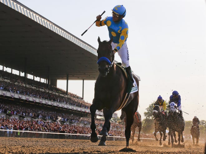 Victor Espinoza crosses the finish line with American Pharoah to win the 147th running of the Belmont Stakes on Saturday at Belmont Park in Elmont, N.Y. American Pharoah is the first horse to win the Triple Crown since Affirmed won it in 1978.