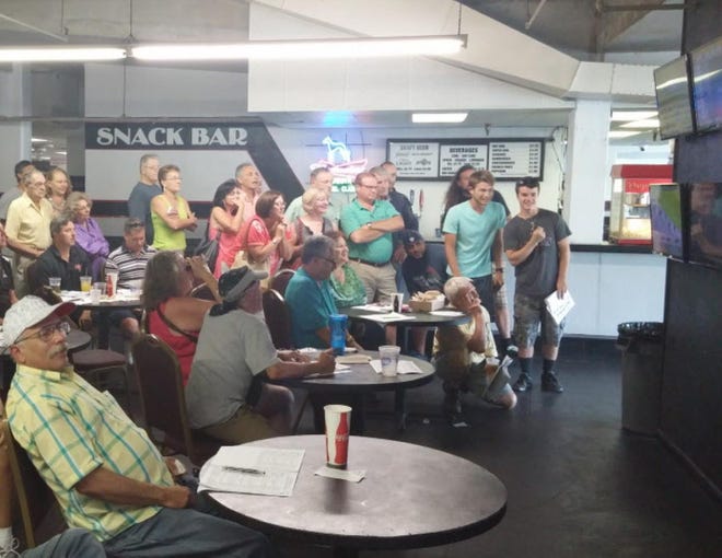 A captivated crowd watches a broadcast of the Belmont Stakes race at the Sarasota Kennel Club on Saturday evening. American Pharoah won the race and claimed the first Triple Crown since 1978.