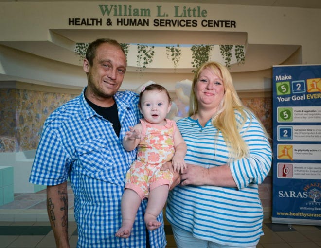 Wayne Wilson, 31, and Melanie Fiscina, 39, hold their 7-month-old daughter Amani Rose Wilson inside the William L. Little Health & Human Services Center in Sarasota. The whole family receives care from this clinic.