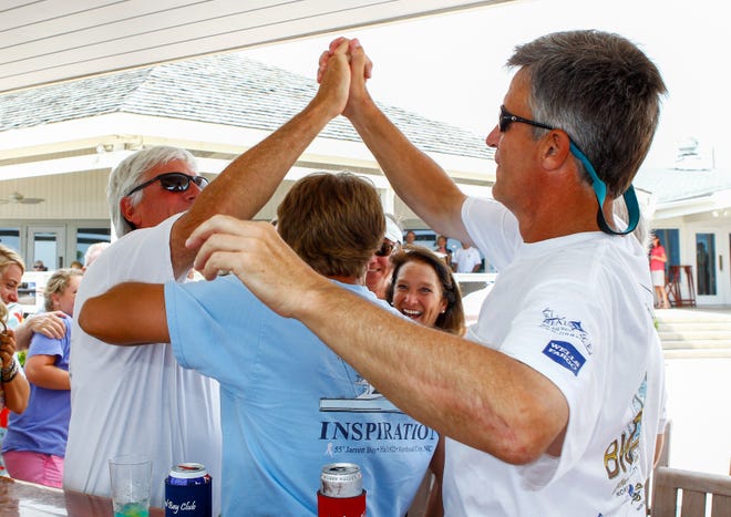 Inspiration captain and owner Casey Wagner (left) celebrates at the Coral Bay Club in Atlantic Beach last year with angler Bruce Brown (right) and his son and first mate, Cole, after learning they had won the 2014 Big Rock Blue Marlin Tournament. The 2015 Big Rock begins Monday and runs through Saturday.