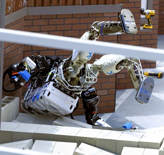 ROBOT RUNNING MAN from the Florida Institute for Human and Machine Cognition takes a tumble during the U.S. Defense Advanced Research Projects Agency Robotics Challenge on Friday.