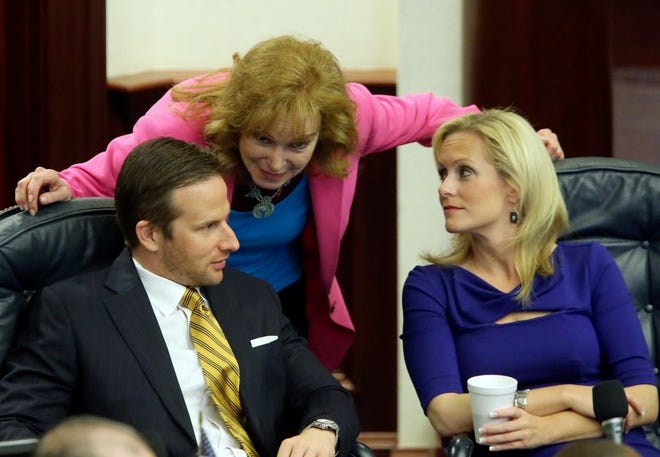 REP. JOHN TOBIA, R-Melbourne Beach, left; Rep. Katie Edwards, D-Plantation, right, and Sen. Eleanor Sobel confer during a debate on the health care bill Friday. This and many other spending issues remain unresolved.