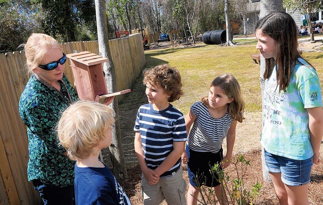 Neval Tucker, outdoor classroom directress, speaks with Timmy Edwards, 8, Kara Marsh, 7, Norah Patterson, 11, and Riley Fahy, 7, about a bluebird house the class put up at Montessori Children’s School in Jacksonville on March 17. John Althouse/The Daily News