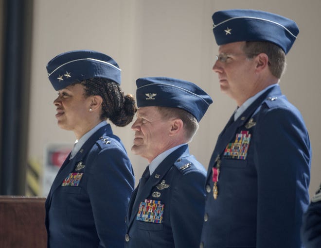 Maj. Gen. Stayce D. Harris, left, stands with incoming 440th Airlift Wing Commander Col. Karl A. Schmitkons, center, and outgoing commander Brig. Gen. James P. Scanlan during a change of command ceremony for the 440th Airlift Wing at Pope Army Airfield Sunday, June 7, 2015.