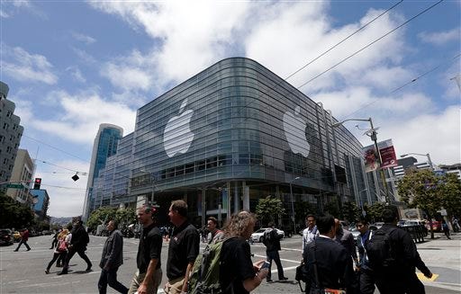 Pedestrians cross the street in front of the Moscone Center, which is hosting the Apple Worldwide Developers Conference, in San Francisco. Apple is expected to announce its new paid streaming-music service at its annual conference for software developers, which kicks off Monday.