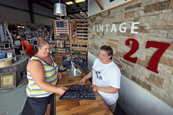 Kathy Chaney of Haines City gets help from store manager Amber Johnson at Vintage 27 in Lake Hamilton on Saturday.