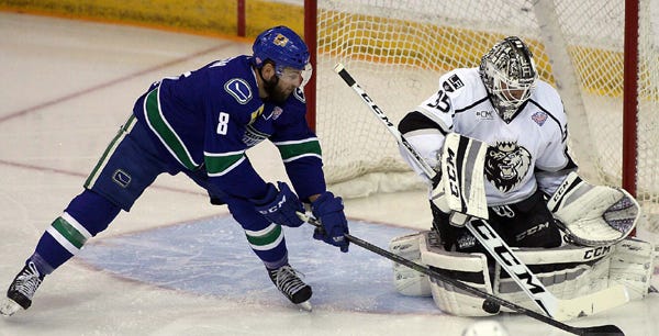 Manchester Monarchs goalie Jean-Francois Berube makes a save as Utica Comets Alex Friesen reaches for the rebound during the first period of Game 2 of the Calder Cup Finals on Sunday in Manchester, N.H. The Monarchs lead the best-of-seven series 2-0.