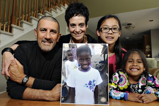 Michael Fichera and Linda Scotto with their two daughters Emma, 11, and 6-year-old Kearly, pose with a photograph of their adopted Congolese daughter, Miriam, at their home in Doylestown, Pa.

Rick Kintzel/The Intelligencer