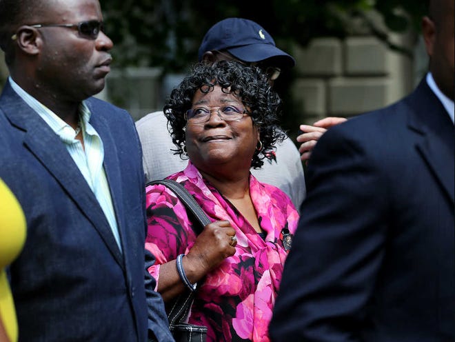 Walter Scott's mother Judy Scott, center, smiles up at her son Rodney Scott, as the family gathers with attorneys for Scott's family outside the Charleston County Courthouse Monday, June 8, 2015, after a Charleston County grand jury handed down an indictment for murder against North Charleston Police Officer Michael Slager in the April 4 shooting death of Walter Scott in Charleston, S.C. Slager fatally shot Scott, who was unarmed, as he was trying to run from a traffic stop. (Grace Beahm/The Post and Courier via AP)