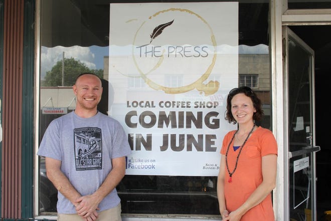 Bethany Morath and her husband, Robert Gordon, stand in front of the sign for their business and the newest addition to Monmouth's growing downtown. The Press, which is set to open in mid-July, will be a coffee shop with a small retail aspect consisting of natural and organic products.