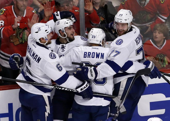 Tampa Bay Lightning's Cedric Paquette, second from left, is congratulated teammates Anton Stralman, left, J.T. Brown, and Victor Hedman, right, after scoring during the third period in Game 3 of the NHL hockey Stanley Cup Final against the Chicago Blackhawks on Monday, June 8, 2015, in Chicago. (AP Photo/Charles Rex Arbogast)