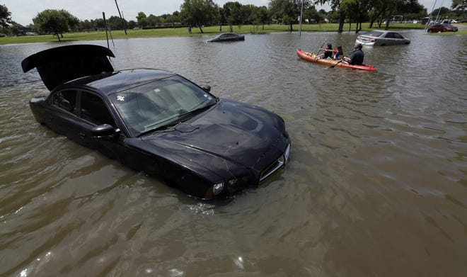 FILE - In this May 26, 2015 file photo a boat is paddled down a flooded street in Houston. Feeling soggy? Federal officials calculate that last month was the wettest on record for the contiguous U.S. On average 4.36 inches of rain and snow fell over the Lower 48 in May, sloshing past October 2009 which had been the wettest month in U.S. records with 4.29 inches. Records go back to 1895. National Oceanic and Atmospheric Administration (NOAA) climate scientist Jake Crouch calculated that comes to more than 200 trillion gallons of water in May. (AP Photo/David J. Phillip, File)