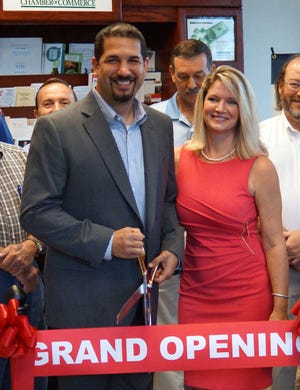 Jamie Parker/Bryan County Now Robert Anthony Olszak, president and founder of Grace Covenant Consulting , and his wife Bianca prepare to cut the ribbon marking the opening of their business in Richmond Hill Tuesday morning.
