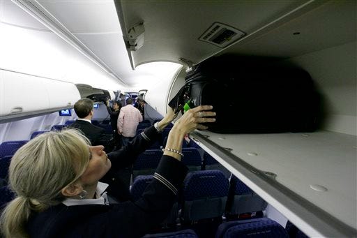 American Airlines flight attendant Renee Schexnaildre demonstrates the overhead baggage area during a media preview of the airline's new Boeing 737-800 jets, at Dallas Fort Worth International Airport in Grapevine, Texas in 2009.