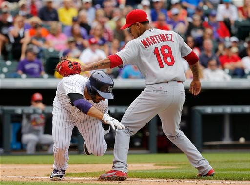 St. Louis Cardinals starting pitcher Carlos Martinez (18) tags out Colorado Rockies' Daniel Descalso (3) during the fourth inning of a baseball game Wednesday, June 10, 2015, in Denver. (AP Photo/Jack Dempsey)