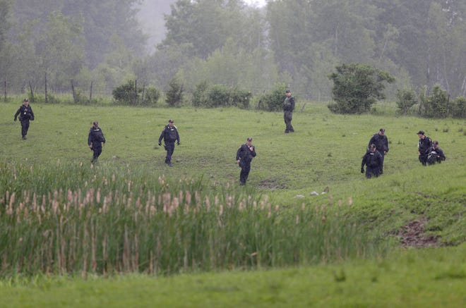 Law enforcement officers search for escaped prisoners near Essex, N.Y., on Tuesday, June 9. State and federal law officers searching for two killers who used power tools to break out of a maximum-security prison poured into a small town 30 miles away Tuesday after getting a report of a possible sighting.