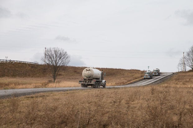 In this file photo, trucks carry water, used in the hydraulic-fracturing process, to and from natural gas drilling sites along Route 6 outside Mansfield and Wellsboro, Pa. For 2014, the Public Utility Commission will distribute $223.5 million across Pennsylvania as part of the Act 13 impact fee program.