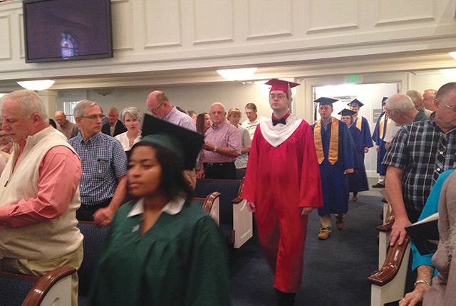 WITH MUCH POMP — On Graduate Sunday, the seniors come to the front of the First Baptist Asheboro sanctuary and are prayed over, then march wearing their caps and gowns. They are presented with a Bible and acknowledged by the congregation. (Photo by Julie Bates) 
 A LIGHT FOR YOUR PATH — Youth Pastor Mark Hall presents a lantern to Carter Huffman as his parents, Jimmy and Melanie, watch. ‘It says we keep a light on. They need to know the way home. There is a light on physically. There is a light on in the heart.’ (Contributed photo) 
 PART OF THE PLAN — At the Parent-Youth Retreat, Julie Bates takes part in ‘Passing of the Blessing’ with her son, Chris. The ritual lets the soon-to-be graduate know he is blessed and created by God for a purpose. (Photo by Mark Hall) 
 GUIDANCE — As part of ‘Passing of the Blessing’ Youth Pastor Mark Hall encourages Madison Williams to continue her life’s journey.(Contributed photo)