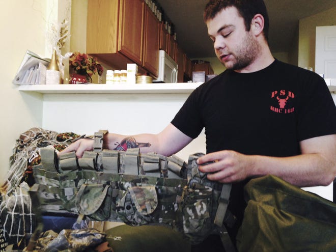 Tony Leys/The Des Moines Register Ryan O'Leary shows an ammunition belt at his West Des Moines apartment May 13 before leaving for Iraq. O'Leary, who served with the Iowa National Guard in Iraq, seeks to train Kurdish troops in their fight against the Islamic State group.